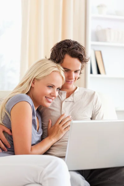 Retrato de um lindo jovem casal usando um laptop — Fotografia de Stock