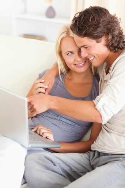 Retrato de um homem mostrando algo para sua esposa em um laptop — Fotografia de Stock