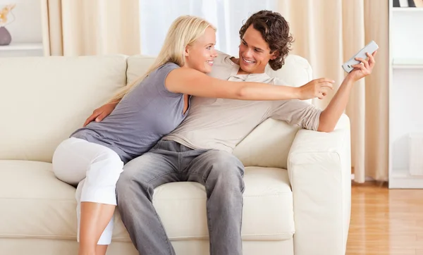 Happy couple fighting for the remote — Stock Photo, Image