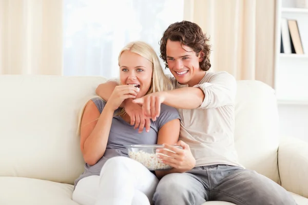 Casal assistindo TV enquanto come pipoca — Fotografia de Stock