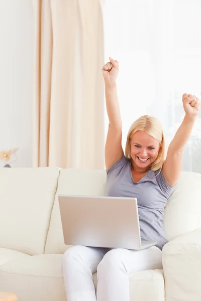 Mulher animando-se ao usar um laptop — Fotografia de Stock