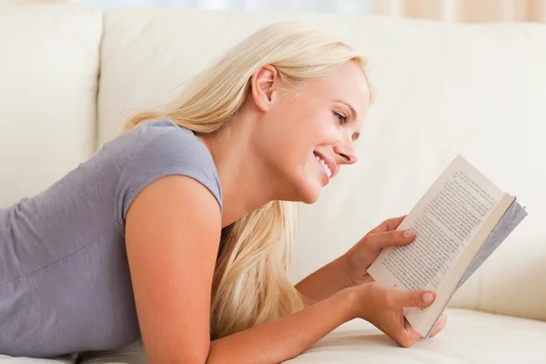 Mulher sorridente lendo um livro — Fotografia de Stock
