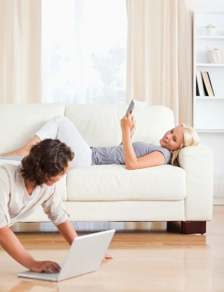 Portrait of a man with a laptop while his wife is with a book — Stock Photo, Image