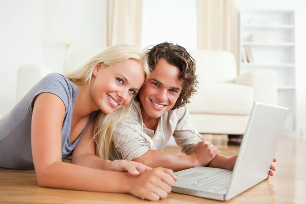 Fechar de um casal sorridente com um laptop — Fotografia de Stock