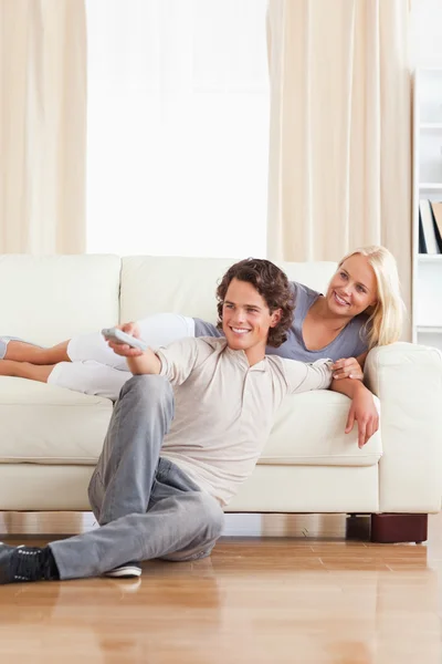 Retrato de um casal sorrindo assistindo TV — Fotografia de Stock