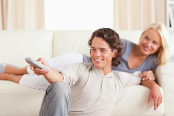 Genç bir çift TV izlerken gülümsüyor — Stok fotoğraf