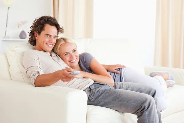 Casal abraços enquanto assiste TV — Fotografia de Stock