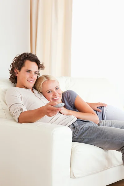 Портрет пары обнимающихся во время просмотра телевизора — стоковое фото
