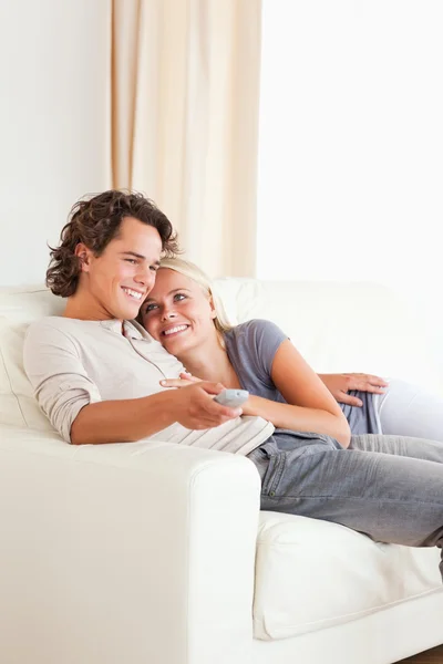 Портрет милой пары, обнимающейся во время просмотра телевизора — стоковое фото