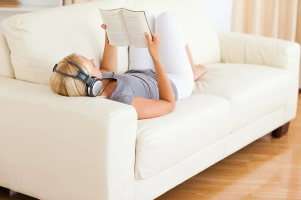 Bir kitap okurken müzik kadın duyuyor — Stok fotoğraf