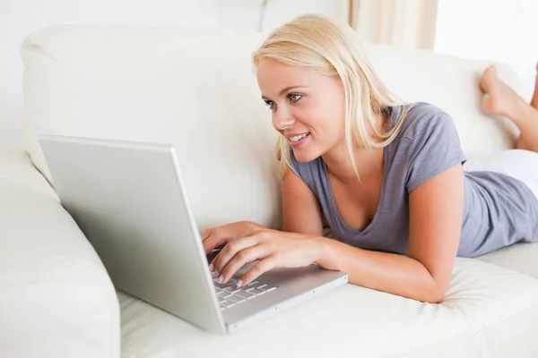 Liegen vrouw met behulp van een laptop — Stockfoto