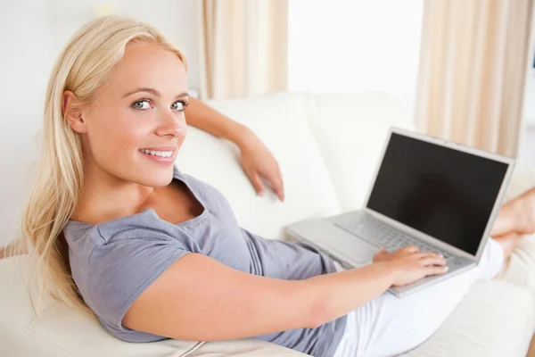 Blonde vrouw over te schakelen op haar laptop — Stockfoto