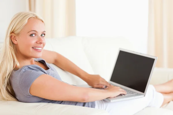 Leende kvinna som använder en bärbar dator — Stockfoto