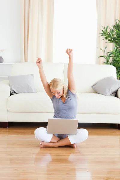Retrato de una mujer alegre con un ordenador portátil mientras está sentado en el —  Fotos de Stock
