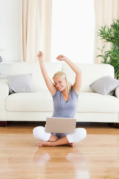 Porträtt av en glad kvinna med en bärbar dator medan du sitter på th — Stockfoto