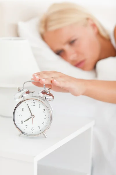Retrato de uma mulher loira despertada por um despertador — Fotografia de Stock