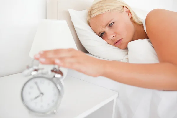 Mulher infeliz despertada por um despertador — Fotografia de Stock