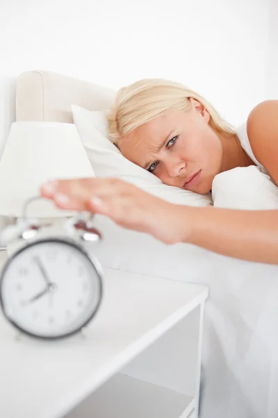 Porträtt av en trött kvinna vaknar av en väckarklocka — Stockfoto