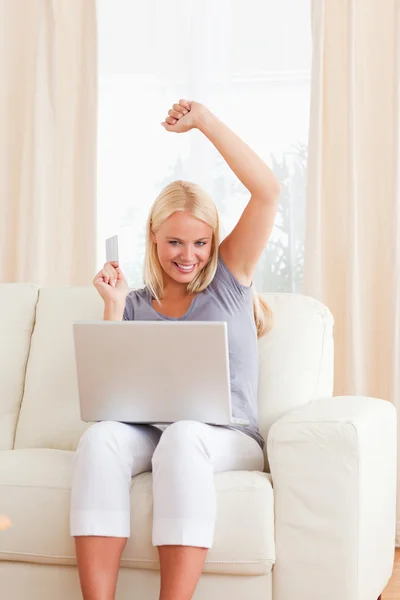 Portrait of a woman cheering while buying online — Stock Photo, Image