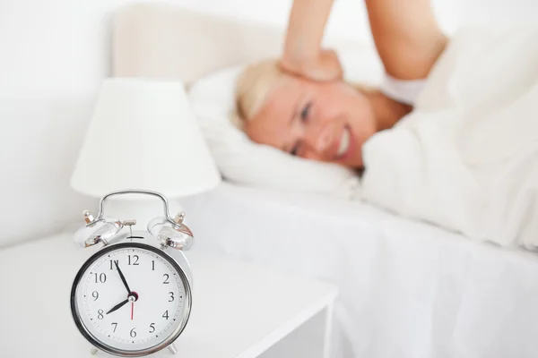 Angry woman awaken by her alarnclock — Stock Photo, Image