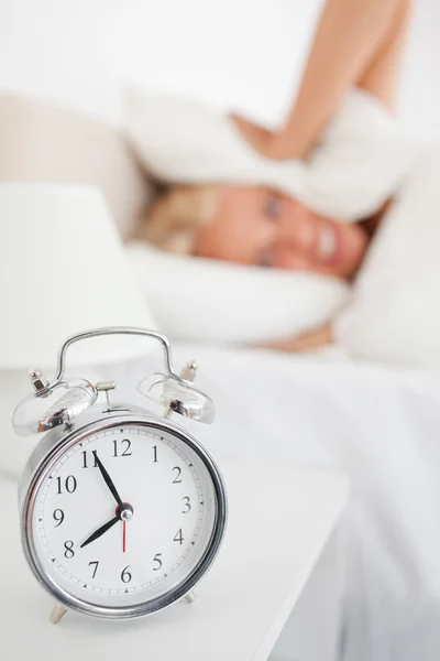 Portret z kobieta hidding głowę w poduszkę podczas alarmu — Zdjęcie stockowe