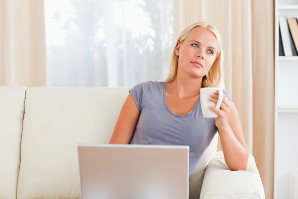 Bir dizüstü bilgisayar basılı tutarak bir kahve olan kadın — Stok fotoğraf