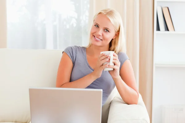 Kvinna med en kopp kaffe medan du håller en anteckningsbok — Stockfoto