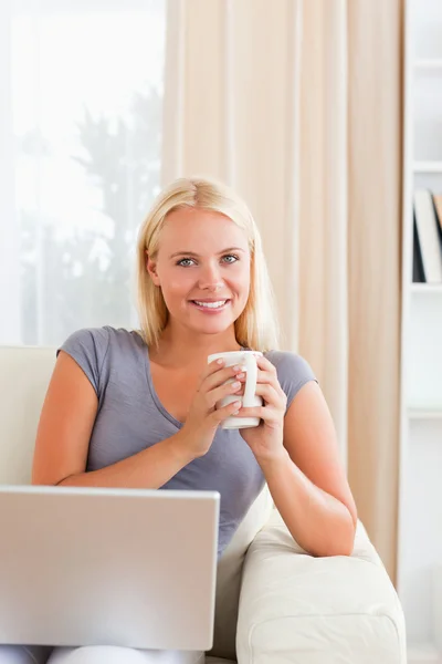 Porträtt av en kvinna med ett te med en bärbar dator — Stockfoto