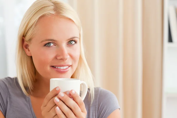 Calm woman sitting on a couch with a cup of tea — Stock Photo, Image