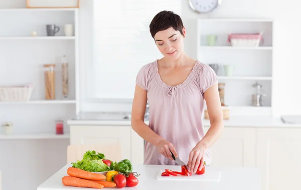 Brunett kvinna skära grönsaker — Stockfoto