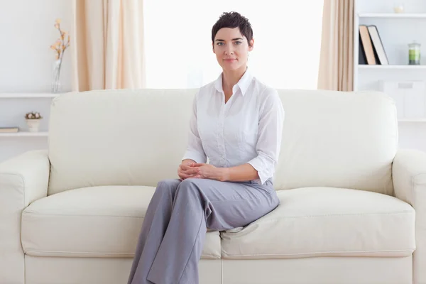 Mulher sentada em um sofá — Fotografia de Stock