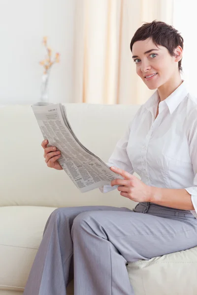 Porträtt av en kvinna som läser nyheterna ser in i kameran — Stockfoto
