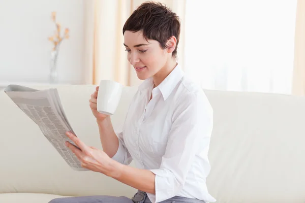 Frau mit einer Tasse beim Nachrichtenlesen — Stockfoto