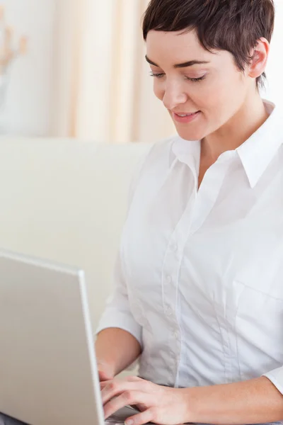 Bir dizüstü bilgisayar ile sevimli bir kadının yakın çekim — Stok fotoğraf