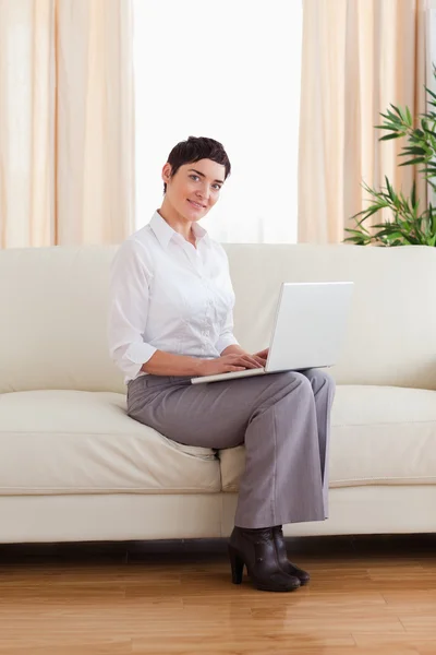 Short-haired woman with a laptop looking into the camera — Stock Photo, Image