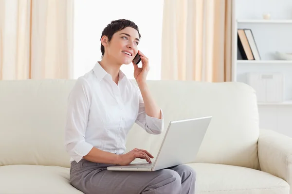 Muhteşem bir kadın ile bir dizüstü bilgisayar ve telefon — Stok fotoğraf