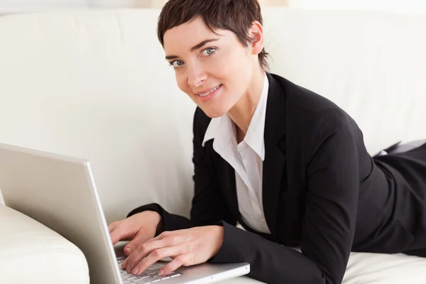 ノート パソコンとソファーに横たわって女性実業家 — ストック写真