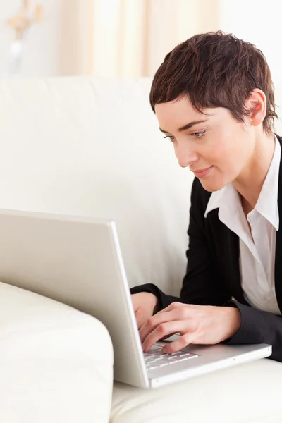 Close up van een zakenvrouw liggen op een bank met een laptop — Stockfoto