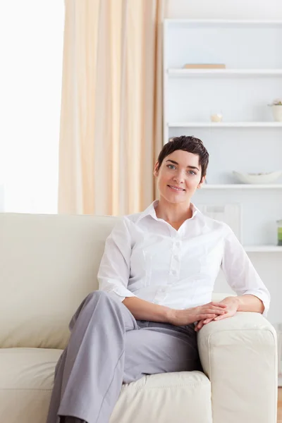 Очаровательная женщина сидит на диване — стоковое фото