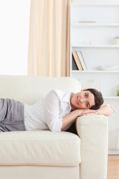 Улыбающаяся женщина лежит на диване — стоковое фото