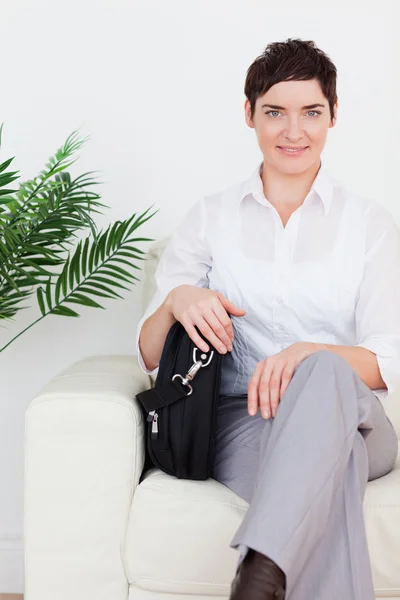 एक सोफा वर बसलेला शॉर्ट हेअर व्यवसाय महिला — स्टॉक फोटो, इमेज