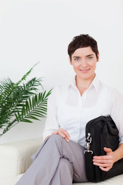 Kurzhaarige lächelnde Geschäftsfrau, die auf einem Sofa sitzt — Stockfoto