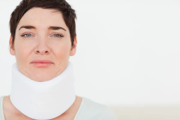 Närbild av en ledsen kvinna med en kirurgisk krage — Stockfoto