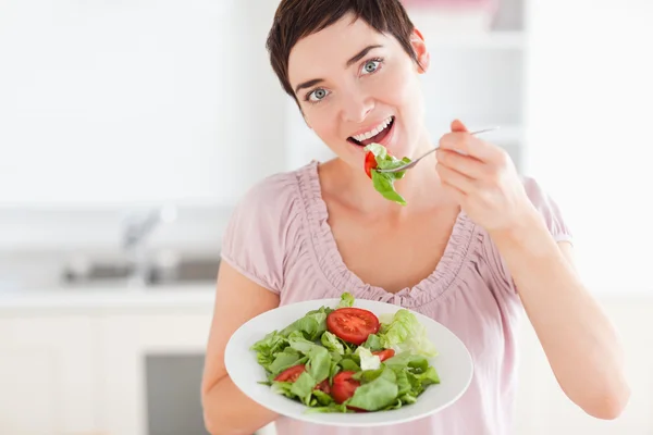 Gut aussehende Frau isst Salat — Stockfoto