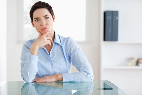 Задумчивая деловая женщина сидит за столом — стоковое фото