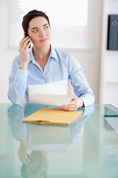 Affärskvinna med papper på telefonen — Stockfoto
