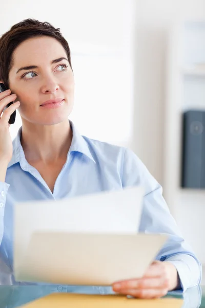 Close up van een zakenvrouw met papieren op de telefoon — Stockfoto