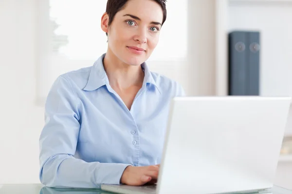 Geschäftsfrau mit Laptop blickt in die Kamera — Stockfoto