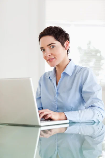 Donna d'affari dai capelli corti con un computer portatile che guarda nella fotocamera — Foto Stock