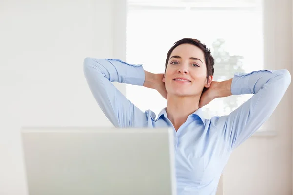 Corto de pelo relajada mujer de negocios con un ordenador portátil mirando en th — Foto de Stock
